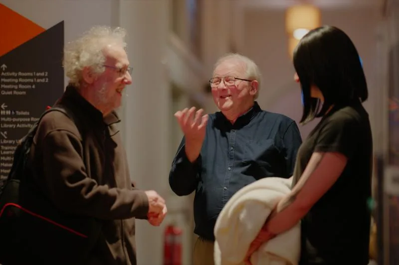 Gallery image: 01 talking 02 june members laughing in the lobby.webp