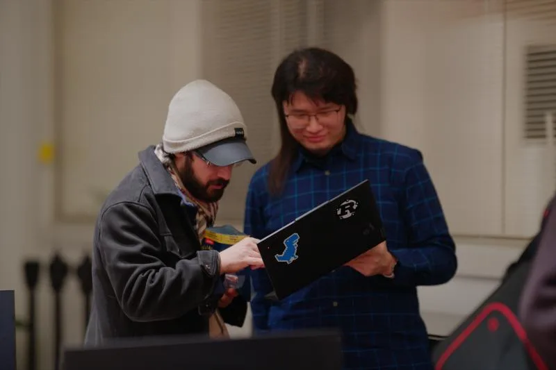Gallery image: 01 talking 06 july two members comparing laptops.webp